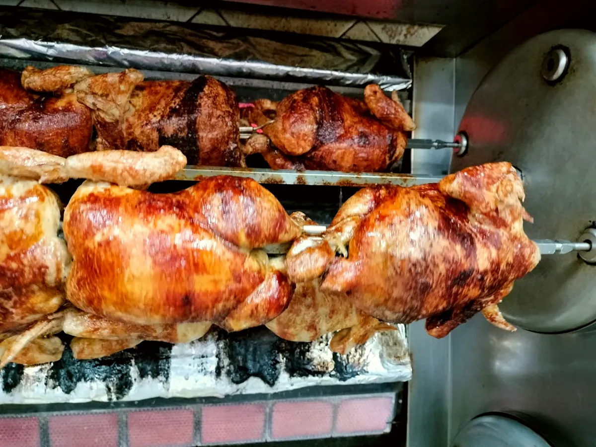 Pollos asados girando en el horno de la tienda